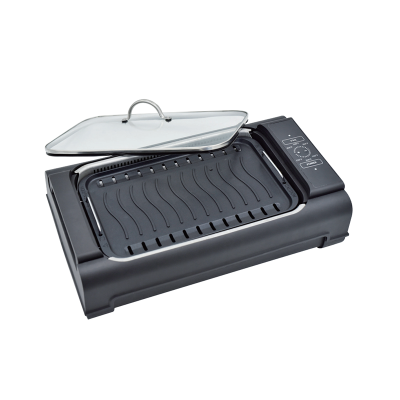 How does a water tray in a smokeless grill help reduce smoke?